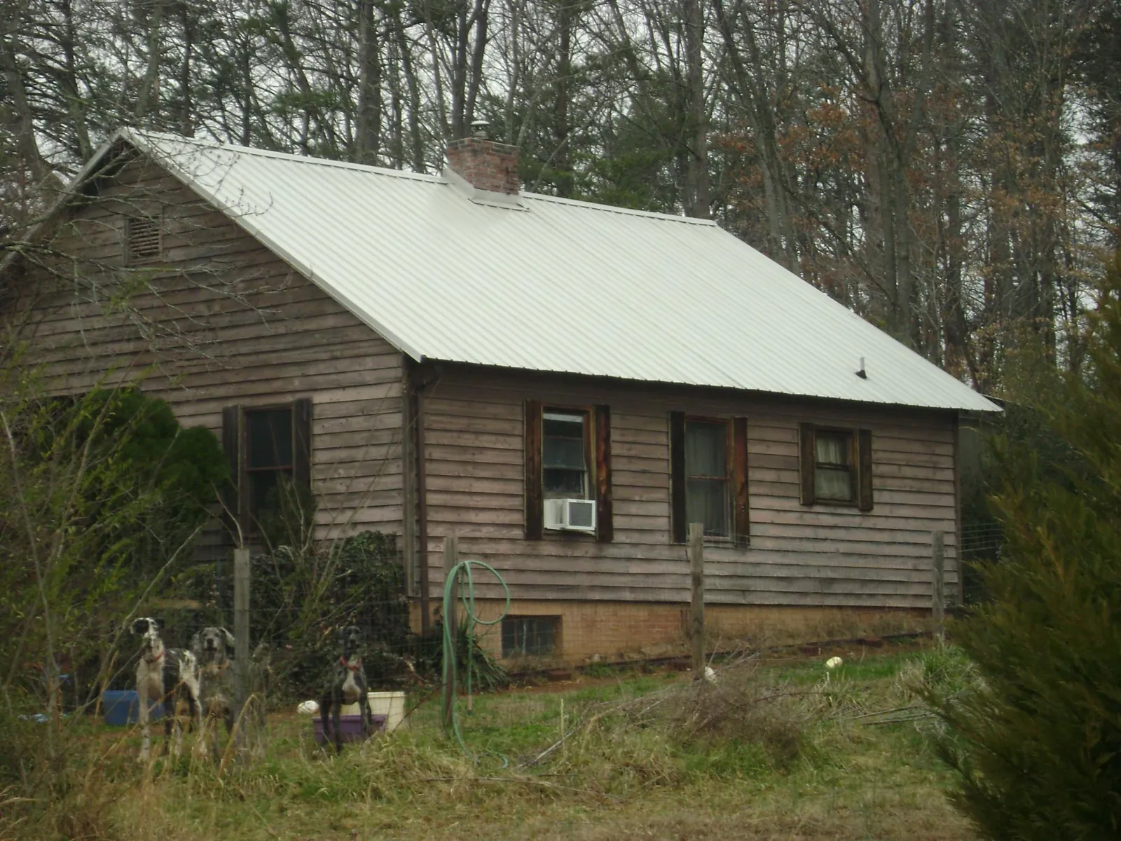 White metal roof on an old wood sided farmhouse, from a Metal Roof Installation job in Pennellville